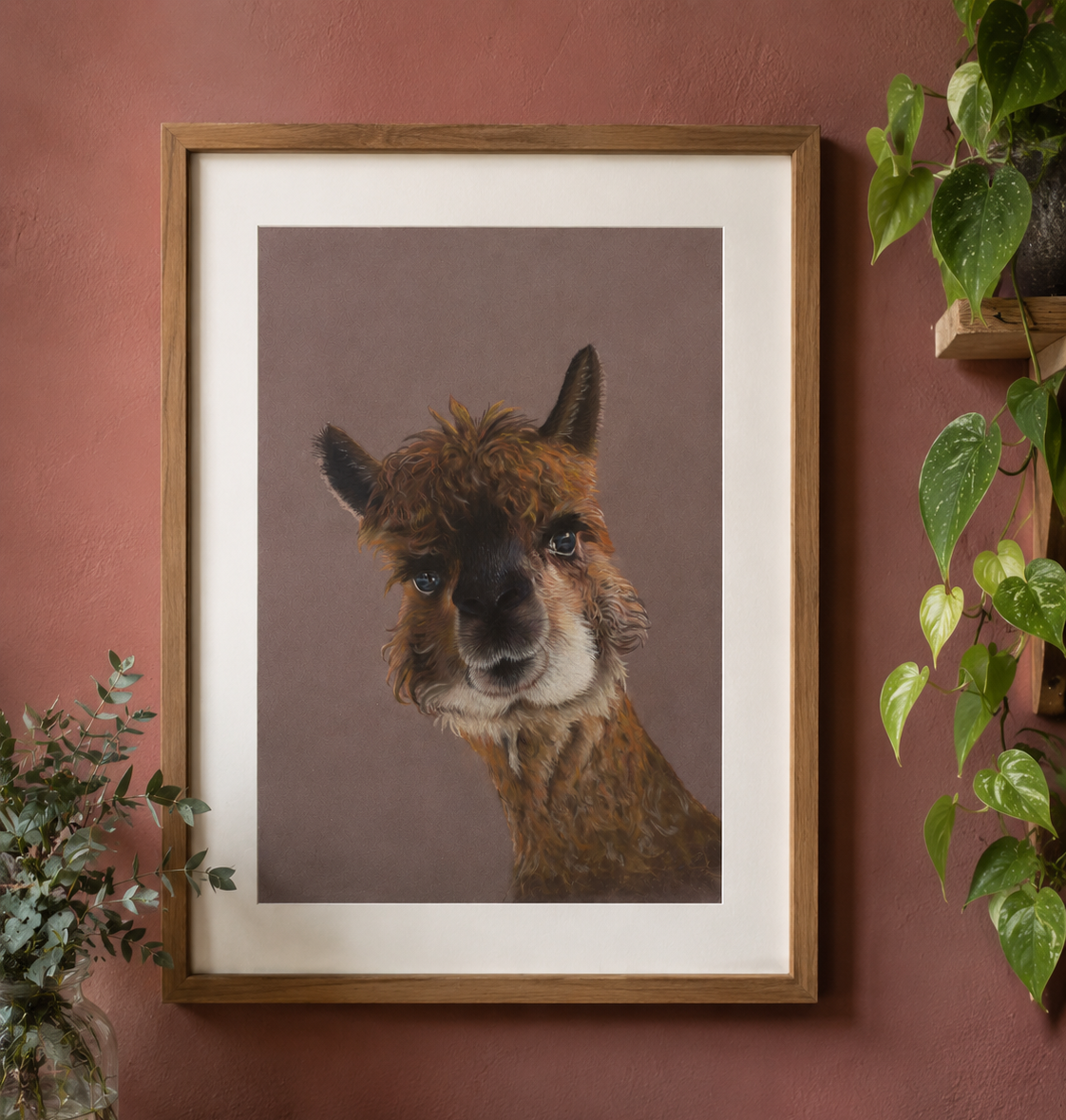Framed artwork of a llama on a wall with plants